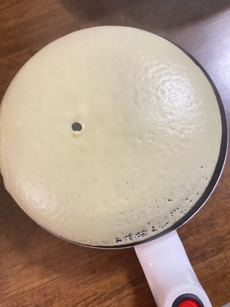 クレープメーカーで生地を焼いている様子