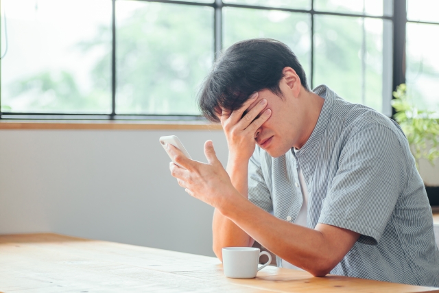 スマホを見て悩む人